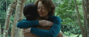 Movie still from “Reaching for the Moon” (2013), directed by Bruno Barreto – Two women hugging each other in a forest; Close Up shot, Over the shoulder angle