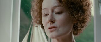 Movie still from “Reaching for the Moon” (2013), directed by Bruno Barreto – A person with curly hair; Close Up shot, Low angle