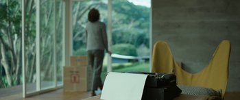 Movie still from “Reaching for the Moon” (2013), directed by Bruno Barreto – A woman standing in front of a sliding glass door; Close Up shot, Over the shoulder angle
