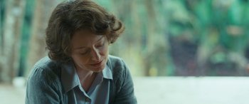 Movie still from “Reaching for the Moon” (2013), directed by Bruno Barreto – A person sitting at a table; Close Up shot, Over the shoulder angle