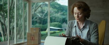 Movie still from “Reaching for the Moon” (2013), directed by Bruno Barreto – A woman sitting in front of an open mailbox; Medium shot, Low angle