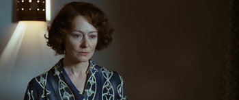 Movie still from “Reaching for the Moon” (2013), directed by Bruno Barreto – A woman in a blue and white shirt looking at the camera; Close Up shot, Over the shoulder angle