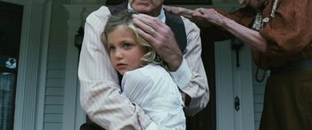 Movie still from “Reaching for the Moon” (2013), directed by Bruno Barreto – An older man holding a young girl in his arms; Close Up shot, Over the shoulder angle