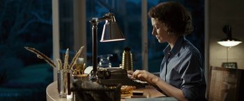 Movie still from “Reaching for the Moon” (2013), directed by Bruno Barreto – A woman typing on an old typewriter at a desk; Medium shot, High angle