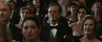 Movie still from “Reaching for the Moon” (2013), directed by Bruno Barreto – An older man in a suit and tie; Close Up shot, Over the shoulder angle