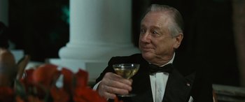 Movie still from “Reaching for the Moon” (2013), directed by Bruno Barreto – An older man in a tuxedo holding a glass of wine; Close Up shot, Low angle