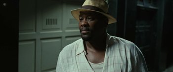 Movie still from “Reaching for the Moon” (2013), directed by Bruno Barreto – A man wearing a hat and a white shirt; Close Up shot, Low angle