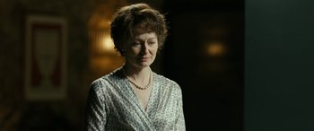 Movie still from “Reaching for the Moon” (2013), directed by Bruno Barreto – A woman in a white shirt and a pearl necklace; Close Up shot, Over the shoulder angle