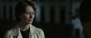 Movie still from “Reaching for the Moon” (2013), directed by Bruno Barreto – A woman with short hair wearing a white jacket; Close Up shot, Over the shoulder angle