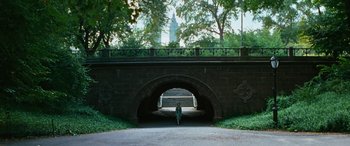 Movie still from “Reaching for the Moon” (2013), directed by Bruno Barreto – A person standing in front of an arch bridge; Extreme Wide shot, High angle
