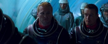 Movie still from “Red Planet” (2000), directed by Antony Hoffman – A man in a space suit standing in front of other men; Medium shot, Over the shoulder angle