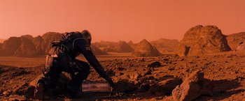 Movie still from “Red Planet” (2000), directed by Antony Hoffman – A person in a spacesuit on the red planet; Wide shot, High angle