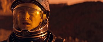 Movie still from “Red Planet” (2000), directed by Antony Hoffman – A space suit helmet with the reflection of the sun in it; Close Up shot, Over the shoulder angle