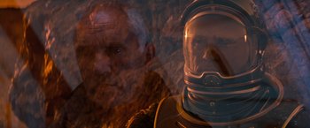 Movie still from “Red Planet” (2000), directed by Antony Hoffman – A man in a space suit and an older man in a space suit; Close Up shot, Overhead angle