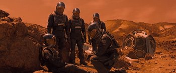Movie still from “Red Planet” (2000), directed by Antony Hoffman – A group of men in space suits on a red planet; Wide shot, High angle
