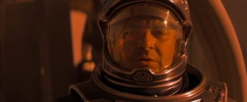 Movie still from “Red Planet” (2000), directed by Antony Hoffman – A man wearing a space suit and a helmet; Close Up shot, Low angle