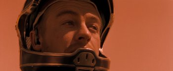 Movie still from “Red Planet” (2000), directed by Antony Hoffman – A person wearing a helmet; Close Up shot, Low angle