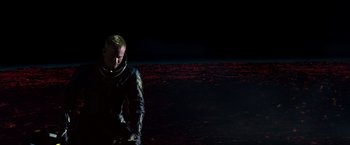 Movie still from “Red Planet” (2000), directed by Antony Hoffman – A man in a spacesuit standing in the dark; Wide shot, Low angle