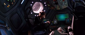 Movie still from “Red Planet” (2000), directed by Antony Hoffman – A person sitting in a chair inside of a space station; Wide shot, High angle