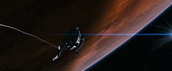 Movie still from “Red Planet” (2000), directed by Antony Hoffman – An image of an astronaut in the outer space; Extreme Wide shot, Overhead angle