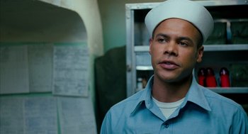 Movie still from “Rescue Dawn” (2006), directed by Werner Herzog – A man wearing a sailor's hat in front of an open cabinet; Close Up shot, Low angle