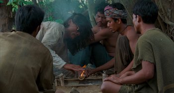 Movie still from “Rescue Dawn” (2006), directed by Werner Herzog – A group of people are gathered around a fire; Medium shot, High angle