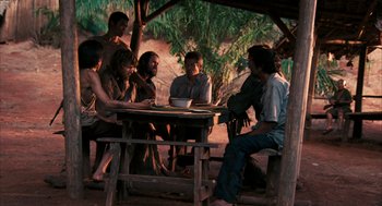 Movie still from “Rescue Dawn” (2006), directed by Werner Herzog – A group of people sitting around a table; Wide shot, Over the shoulder angle