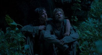 Movie still from “Rescue Dawn” (2006), directed by Werner Herzog – Two men are hugging in the woods at night; Medium shot, Low angle