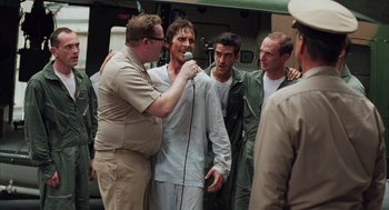 Movie still from “Rescue Dawn” (2006), directed by Werner Herzog – A group of men standing next to each other on a field; Medium shot, Over the shoulder angle