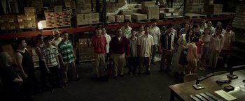 Movie still from “Revenge of the Green Dragons” (2014), directed by Andrew Loo – A group of people standing in a warehouse; Wide shot, High angle