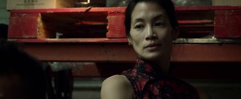 Movie still from “Revenge of the Green Dragons” (2014), directed by Andrew Loo – A person wearing a red and black dress; Close Up shot, Over the shoulder angle
