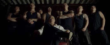Movie still from “Revenge of the Green Dragons” (2014), directed by Andrew Loo – A group of men standing next to each other in a room; Medium shot, Low angle