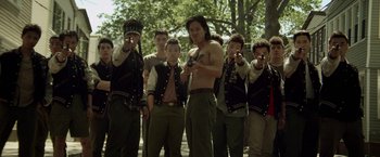 Movie still from “Revenge of the Green Dragons” (2014), directed by Andrew Loo – A group of young men standing next to each other holding guns; Medium shot, Over the shoulder angle