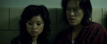 Movie still from “Revenge of the Green Dragons” (2014), directed by Andrew Loo – A couple of people sitting next to each other on a bench; Close Up shot, Over the shoulder angle
