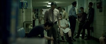 Movie still from “Revenge of the Green Dragons” (2014), directed by Andrew Loo – A group of men standing around a room; Wide shot, Low angle