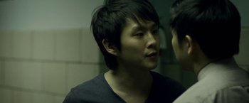 Movie still from “Revenge of the Green Dragons” (2014), directed by Andrew Loo – A man with a black shirt is looking into the mirror; Close Up shot, Over the shoulder angle