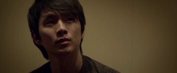 Movie still from “Revenge of the Green Dragons” (2014), directed by Andrew Loo – A person wearing a black shirt; Close Up shot, Low angle