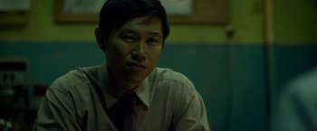 Movie still from “Revenge of the Green Dragons” (2014), directed by Andrew Loo – A person wearing a shirt and a tie; Close Up shot, Over the shoulder angle