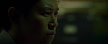 Movie still from “Revenge of the Green Dragons” (2014), directed by Andrew Loo – A person's face in the dark; Close Up shot, Low angle