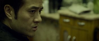 Movie still from “Revenge of the Green Dragons” (2014), directed by Andrew Loo – A man's face in a dark room; Close Up shot, Over the shoulder angle