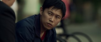 Movie still from “Revenge of the Green Dragons” (2014), directed by Andrew Loo – A person wearing a jacket; Close Up shot, Low angle