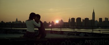 Movie still from “Revenge of the Green Dragons” (2014), directed by Andrew Loo – Two people are kissing on the side of a bridge; Wide shot, High angle