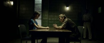 Movie still from “Revenge of the Green Dragons” (2014), directed by Andrew Loo – A man and a woman sitting at a table in front of each other; Medium shot, High angle