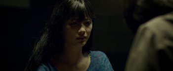 Movie still from “Revenge of the Green Dragons” (2014), directed by Andrew Loo – A young woman with long black hair looking at the camera; Close Up shot, Over the shoulder angle