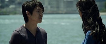 Movie still from “Revenge of the Green Dragons” (2014), directed by Andrew Loo – A man standing next to a body of water; Close Up shot, Low angle