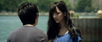 Movie still from “Revenge of the Green Dragons” (2014), directed by Andrew Loo – A young woman standing next to a young man near a body of water; Close Up shot, Over the shoulder angle