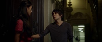 Movie still from “Revenge of the Green Dragons” (2014), directed by Andrew Loo – A man and a woman standing next to each other; Medium shot, Over the shoulder angle