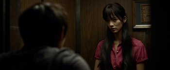 Movie still from “Revenge of the Green Dragons” (2014), directed by Andrew Loo – A woman in a red shirt in front of a mirror; Close Up shot, Over the shoulder angle