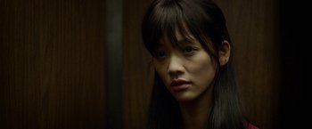 Movie still from “Revenge of the Green Dragons” (2014), directed by Andrew Loo – A person with long black hair; Close Up shot, Over the shoulder angle