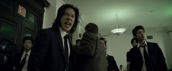 Movie still from “Revenge of the Green Dragons” (2014), directed by Andrew Loo – A group of people in suits and ties; Medium shot, Low angle